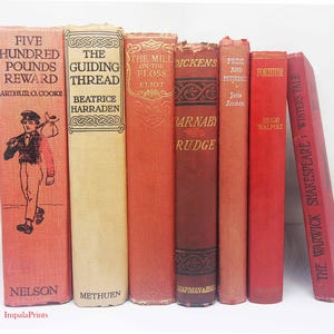 Puede incluir: Una colección de ocho libros antiguos de tapa dura con lomos rojos. Los títulos incluyen "Five Hundred Pounds Reward", "The Guiding Thread", "The Mill on the Floss", "Barnaby Rudge", "Pride and Prejudice", "Fortitude" y "The Warwick Shakespeare: Winters Tale".