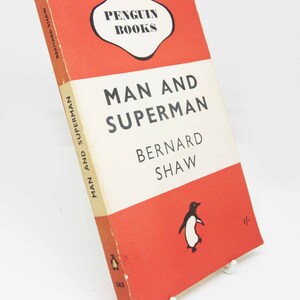 May include: A red and white Penguin Books paperback edition of "Man and Superman" by Bernard Shaw. The cover features a penguin illustration and the Penguin Books logo.