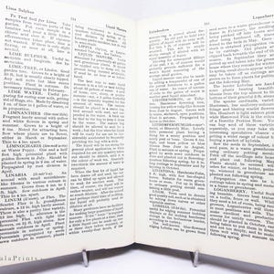 May include: Open book with botanical text, featuring pages with printed text and a visible metal book stand. The text includes information on plants, gardening, and soil testing. The book is open to display the text, with the Impala Prints logo at the bottom.
