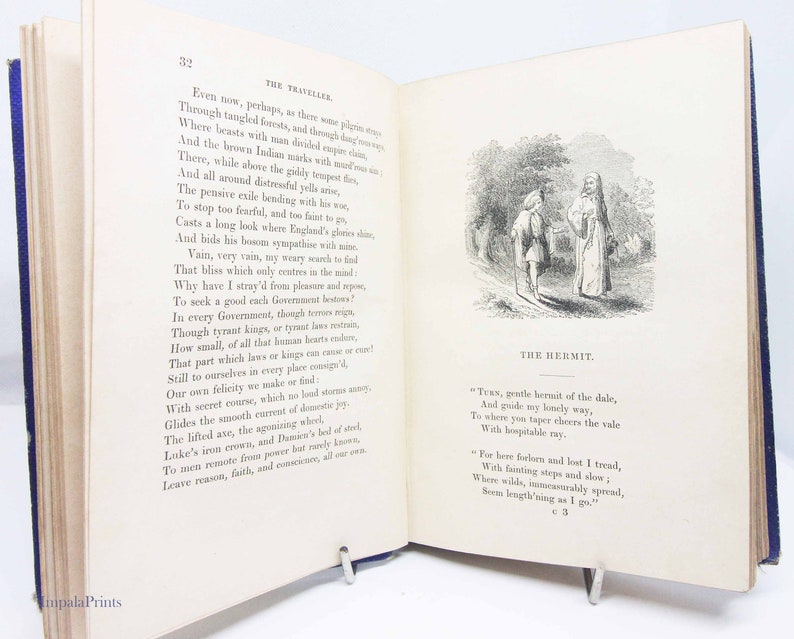 May include: An open book with a black and white illustration of a man and a hermit in a forest setting. The book has text on the pages, including the title "The Hermit".