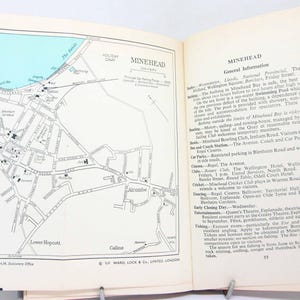 May include: Open book with a detailed black and white map of Minehead, England, on the left page. The right page features text titled "MINEHEAD" with general information. The book is held open with metal clips.