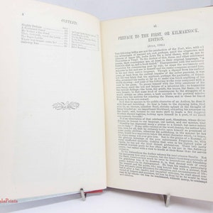 Pode incluir: Um livro aberto exibindo uma p&aacute;gina de &iacute;ndice &agrave; esquerda e uma p&aacute;gina de pref&aacute;cio &agrave; direita. O texto est&aacute; impresso em tinta preta sobre papel branco sujo. A p&aacute;gina esquerda lista t&iacute;tulos e a p&aacute;gina direita cont&eacute;m um longo par&aacute;grafo.