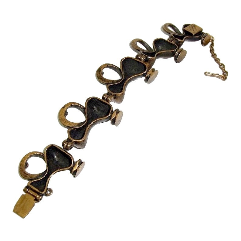 May include: A bronze bracelet with a chain closure. The bracelet is made up of a series of linked, heart-shaped pieces.