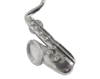 May include: A silver saxophone pin, a detailed miniature replica of a musical instrument.