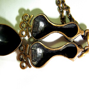 May include: A gold-tone necklace with a pendant featuring two stylized figures. The pendant is marked "L. Dalize, France".