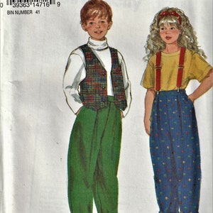 May include: A sewing pattern for children's clothing. The pattern includes instructions in English, French, and Spanish. The pattern is for a green vest with a plaid pattern and a pair of blue overalls with white polka dots.