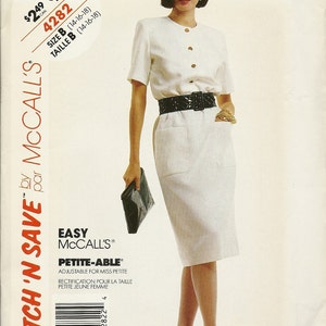 May include: A white dress with a black belt and a black purse. The dress has a button-up front and short sleeves. The dress is labeled "Easy McCall's Petite-Able" and "Adjustable for Miss Petite".