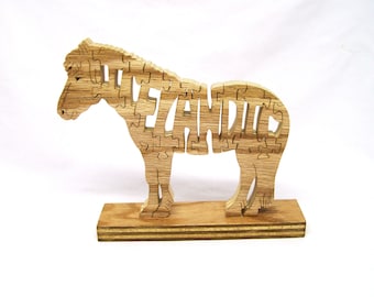 May include: Wooden zebra puzzle with the name "ZEYANDIE" cut out of the body. The zebra is standing on a wooden base.