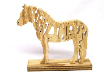 May include: Wooden puzzle of a horse, made of interlocking pieces. The horse is standing on a wooden base.