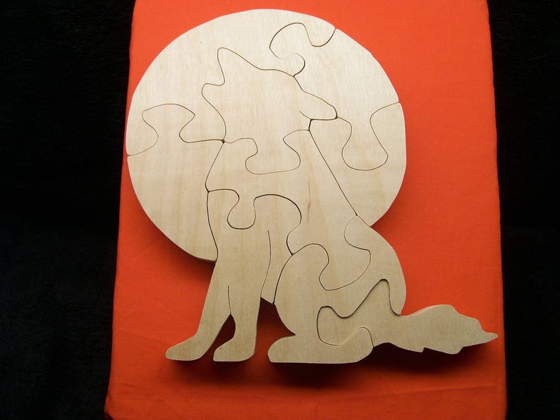 May include: A wooden puzzle of a wolf howling at the moon. The puzzle is made up of several pieces that fit together to form the image of the wolf.