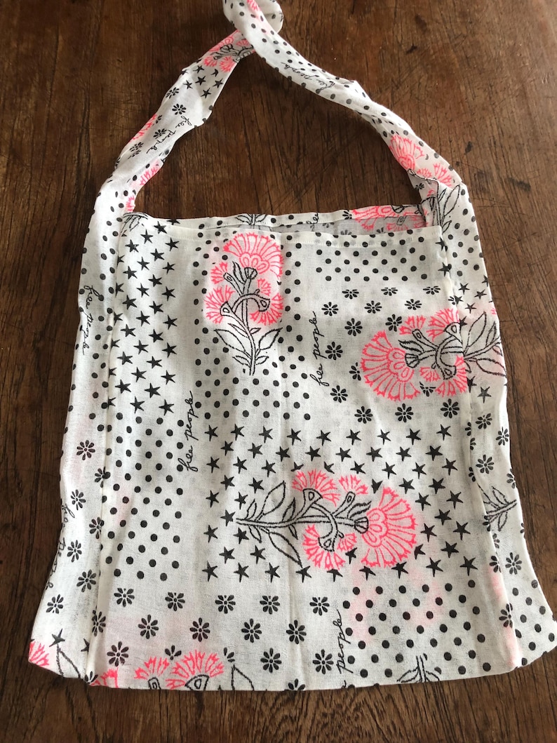 Puede incluir: Top halter blanco con estampado floral y de estrellas. El top presenta flores rosas, estrellas negras y lunares negros. Las correas son blancas con lunares negros. Las palabras "free people" est&aacute;n impresas.