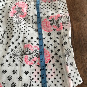 Puede incluir: Bolso tote blanco con un estampado floral y de estrellas. El bolso presenta dise&ntilde;os florales rosas y negros, estrellas negras y lunares negros. El bolso mide aproximadamente 40 cm de largo.