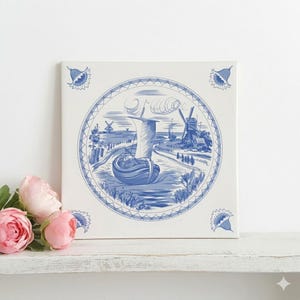May include: Square ceramic tile with a blue and white Dutch Delft design. The artwork depicts a sailboat on a river, windmills, and a village scene. The tile is framed by a decorative border and floral accents in each corner.