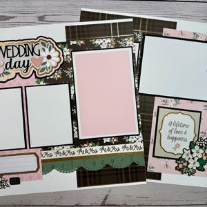 May include: Wedding-themed scrapbook pages with floral and heart embellishments. The pages feature photo frames, decorative borders, and the text "Wedding Day" and "a lifetime of love & happiness."