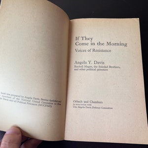 May include: Book cover with the title "If They Come in the Morning: Voices of Resistance" by Angela Y. Davis, Ruchell Magee, the Soledad Brothers, and other political prisoners. Published by Orbach and Chambers in association with The Angela Davis Defence Committee.