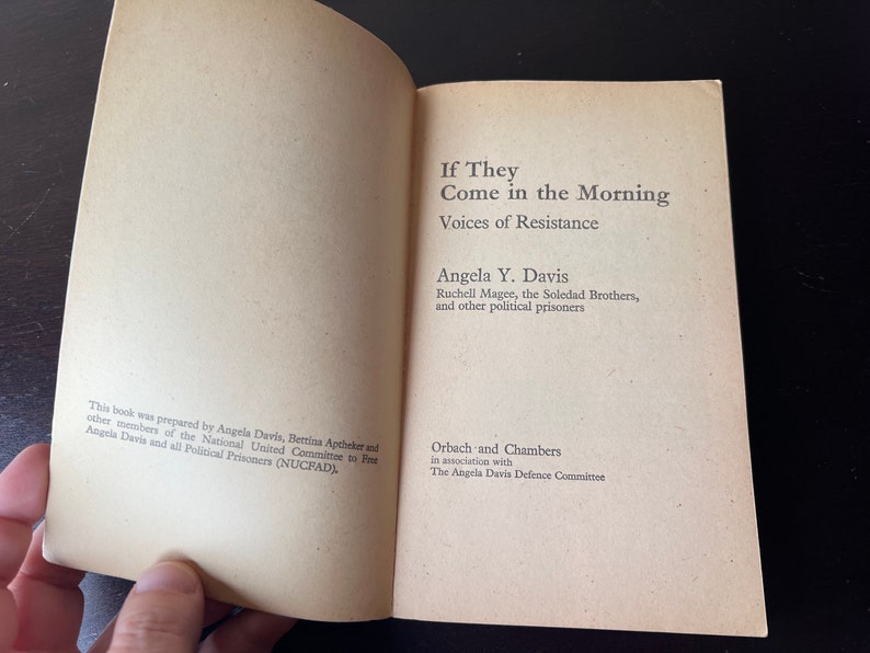 May include: Book cover with the title "If They Come in the Morning: Voices of Resistance" by Angela Y. Davis, Ruchell Magee, the Soledad Brothers, and other political prisoners. Published by Orbach and Chambers in association with The Angela Davis Defence Committee.