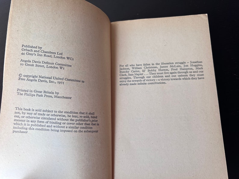 May include: A book titled "Free Angela Davis" with a copyright notice and publishing information. The book is about the liberation struggle and includes the names of those who have fallen in the struggle.