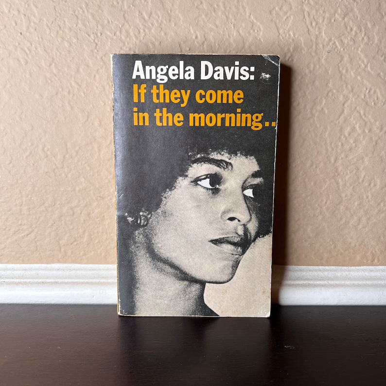 May include: A black and white photograph of Angela Davis on the cover of her book, "If they come in the morning..."