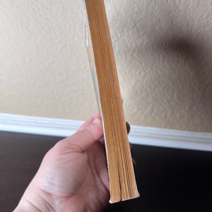 May include: The spine of a paperback book with a yellow cover. The book is closed and the spine is visible.
