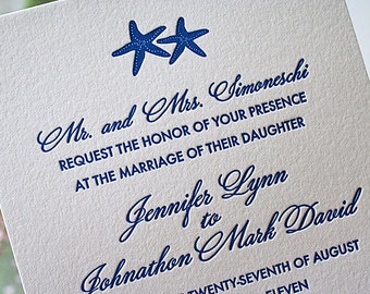 May include: A white wedding invitation with blue text and two blue starfish. The text reads "Mr. and Mrs. Simoneschi request the honor of your presence at the marriage of their daughter Jennifer Lynn to Johnathon Mark David Twenty-seventh of August Eleven"