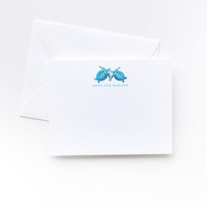 May include: White stationery set featuring a folded card and envelope. The card is adorned with two blue sea turtles and the text "ANNA LEE WARNER" in a matching blue font. The stationery set is perfect for sending personalized notes.