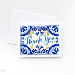 May include: A white card with a blue and white patterned border. The border features a repeating design of lemons and leaves. The text "Thank You" is written in blue cursive script in the center of the card.