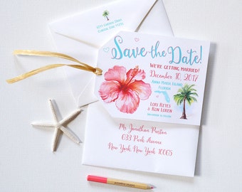 May include: Save the date card with a pink hibiscus flower and a palm tree. The text reads "Save the Date! We're getting married! December 10, 2017 Anna Maria Island Florida Lori Reyes & Ron Loren Invitation to follow Mr. Jonathan Preston 633 Park Avenue New York, New York 10065"