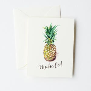 May include: A watercolor illustration of a pineapple with the word "mahalo!" written in cursive below it. The pineapple is yellow and green and has a brown stem.