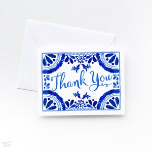 May include: Blue and white thank you card with a decorative border and the words "Thank You" in blue cursive lettering.