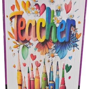May include: A folded book art piece featuring the word "Teacher" in rainbow hues, adorned with colourful flowers, hearts, and pencils. The book has a purple spine, and the pages are folded to create the design.