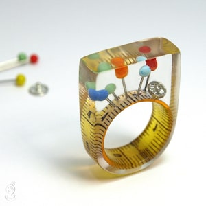 Sewing basket – extraordinary sewing supplies ring with measuring tape, colorful fixing pins & snap fastener on a yellow ring made of resin