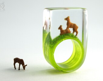 Bague cerf "Waldesruh" - avec deux cerfs miniatures marron sur un anneau à carreaux verts et blancs et herbe printanière en résine coulée