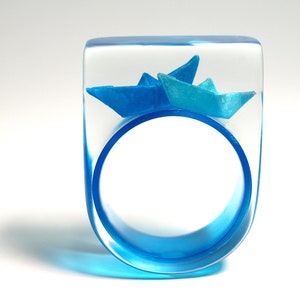 Ship ahoy maritime boat ring with hand-made folded mini boats made of light blue and blue paper on a blue ring made of resin light blue/blue