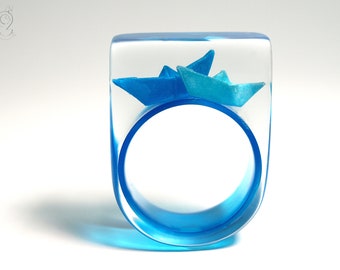 Ship ahoy – maritime boat ring with hand-made folded mini boats made of light blue and blue paper on a blue ring made of resin