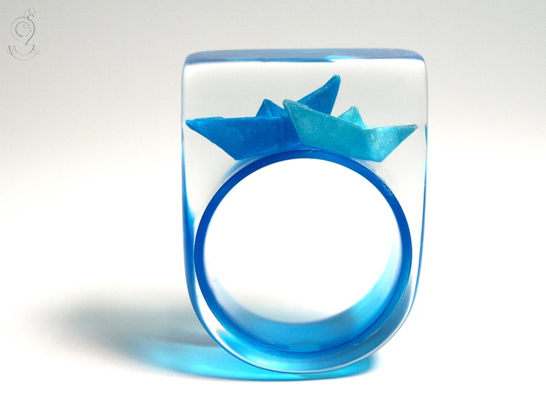 Ship ahoy maritime boat ring with hand-made folded mini boats made of light blue and blue paper on a blue ring made of resin light blue/blue