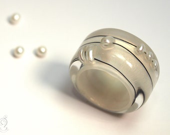 Abstrakter Perlen-Ring "Rundblick" aus Gießharz mit echten weißen Perlen und Draht auf perlweißem Ring