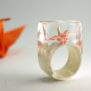 Origami-Kranich Ring – Flatterndes Glück – mit selbst gefalteten Mini-Kranich aus buntem Papier auf Blattweißgold oder -gold in Epoxidharz