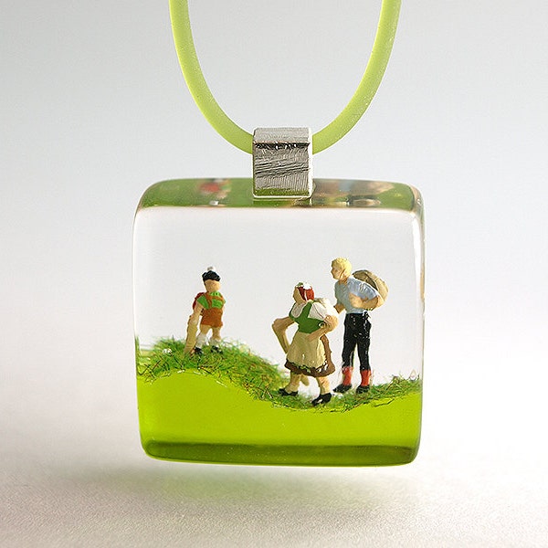 Wanderlust – jaunty climber figures pendant with three mini hikers on a green floor with grass made of resin for all backpackers