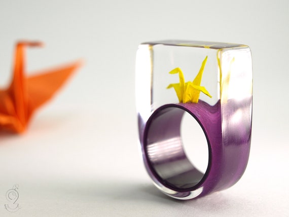 Origami Kranich Ring Flatterndes Glück Mit Selbst Gefalteten Mini Kranich Aus Gelbem Papier Auf Einem Lila Ring In Gießharz