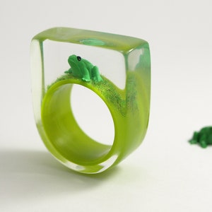 Froschkönig Drolliger Epoxidharz-Ring mit einem grünen Frosch und Gras auf knallgrünem Ring von Geschmeide unter Teck Bild 1