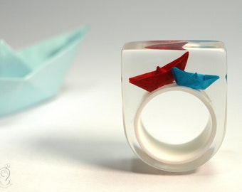 Papier-Boote-Ring "Schiff Ahoi" mit selbst gefalteten Mini-Booten aus rotem und blauem Papier auf weißem Ring in Epoxidharz