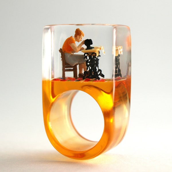 Sewing Machine – Handmade sewing ring with a mini seamstress and her sewing machine on an orange ring made of resin