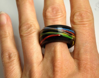 Long line – electrotechnical ring with intertwined colorful copper cables on a colorful ring made of resin