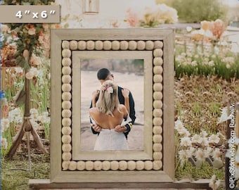 May include: A rectangular photo frame, 4" x 6", with a light-colored wooden frame and a beaded border. The frame holds a photo of a couple. The frame is displayed outdoors with flowers in the background.