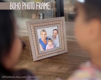 May include: A square, light-colored photo frame with a beaded border. The frame holds a family portrait. The text "BOHO PHOTO FRAME" is at the top of the image. The frame is on a wooden surface.