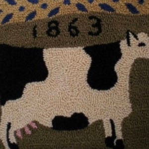 May include: A brown and white rug with a black and white cow design. The rug has the year 1863 stitched into it.