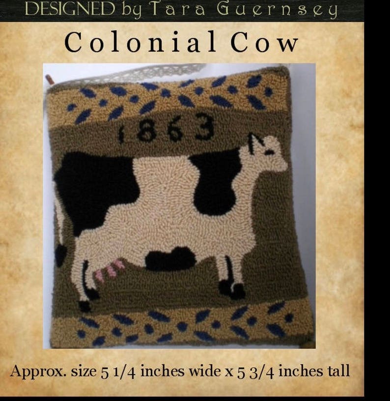 May include: A brown and tan pillow with a black and white cow design. The pillow has a green background and the year 1863 is printed on the top. The pillow is approximately 5 1/4 inches wide and 5 3/4 inches tall.