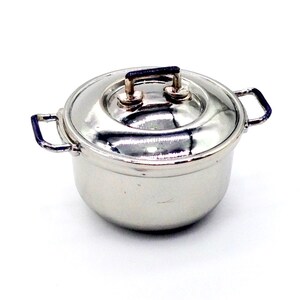 May include: A silver pot with a lid and two handles. The pot has a shiny, metallic finish.