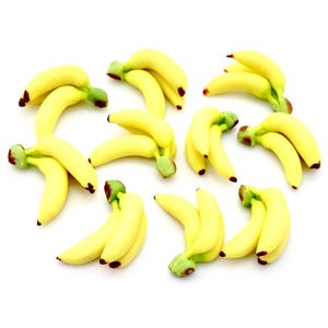 May include: A group of 11 yellow bananas arranged in a cluster on a white background. The bananas are all ripe and have a slight curve to them.