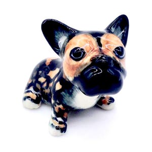 以下が含まれることがあります： 黒、白、オレンジの模様のついたフレンチブルドッグの子犬のセラミック製置物。置物は座って、頭を上げて、目を閉じている。
